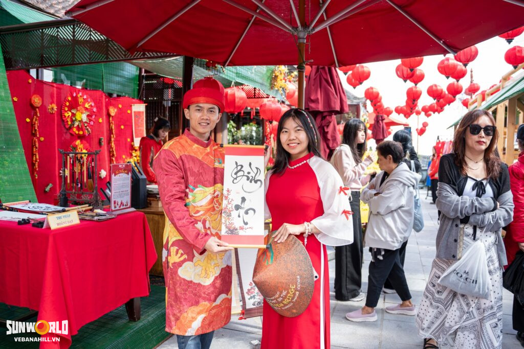 Du khách nhận chữ thư pháp với lời chúc may mắn khi du xuân Bà Nà Hills.