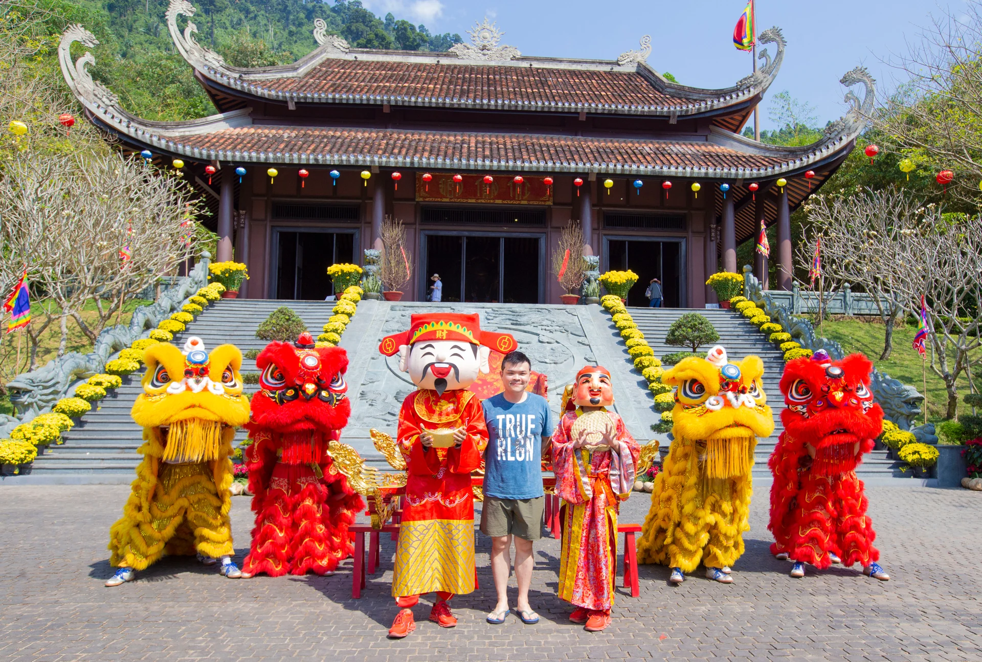 신의 산에서 사자춤을 추는 예술가들 사이에 서 있는 남자, 밝은 장식 배경.