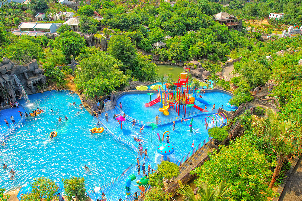 Công viên nước Núi Thần Tài với hồ bơi xanh mát và khu vui chơi cho trẻ em.