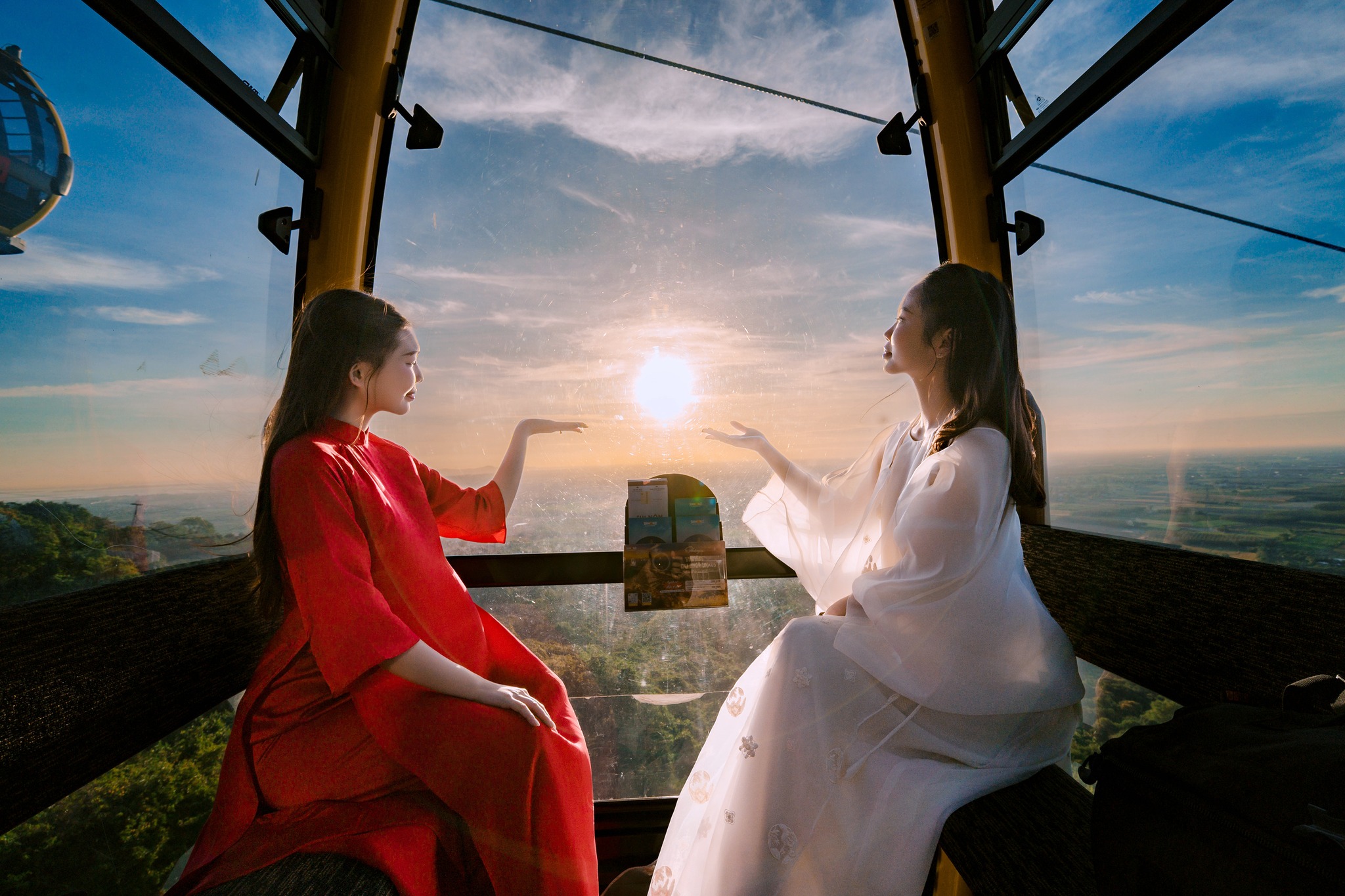 Hai cô gái ngồi trong cabin cáp treo ngắm hoàng hôn.